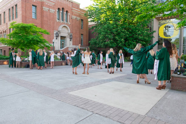 University of Oregon College Graduates on Campus EUGENE, OR - MAY 22, 2017: Sorority sisters in the Lillis business plaza for graduation photos on campus at the University of Oregon in Eugene. sorority photos stock pictures, royalty-free photos & images