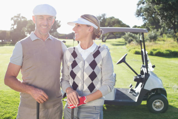 istock Happy golfing couple with golf buggy behind 692041008