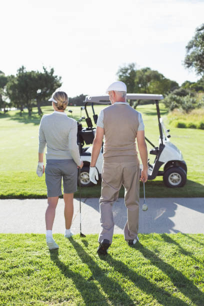 istock Happy golfing couple walking towards the buggy 692041226