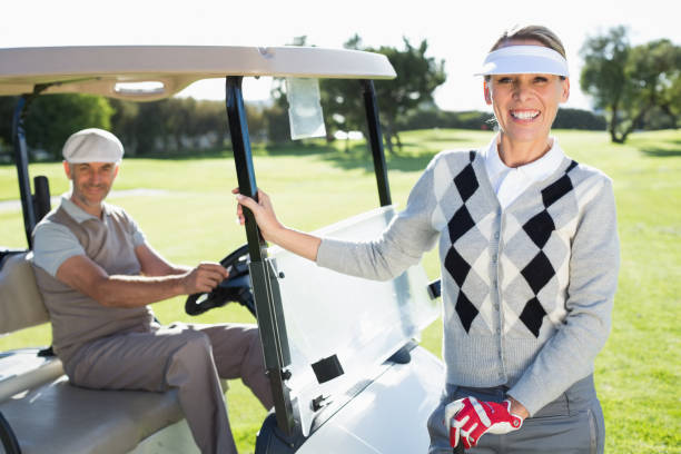 istock Happy golfing couple smiling at camera with their buggy 692043372