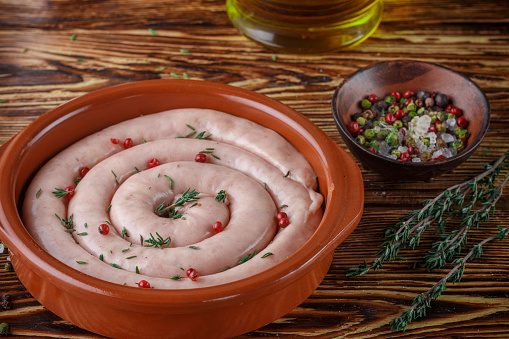 Raw homemade chicken sausage with spices and thyme. Selective focus