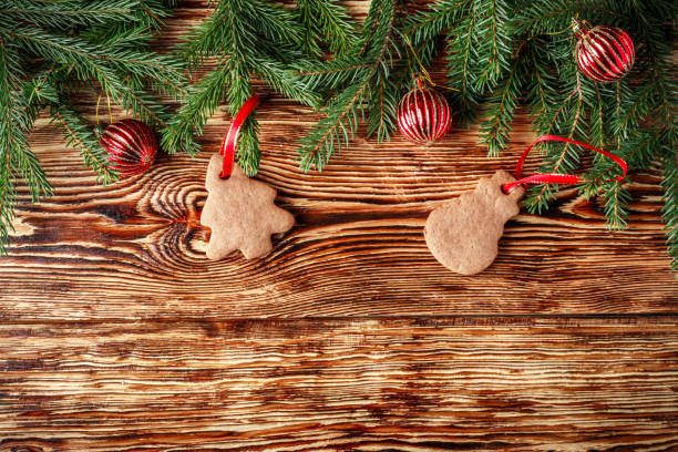 istock Christmas background. Fir branches, red balls, gingerbread on the old brown boards. Rustic style.  Copy space. Top view 692052578