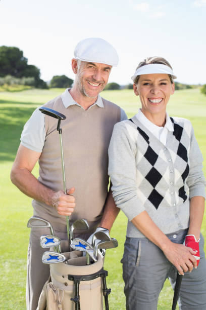 istock Golfing couple smiling at camera on the putting green 692055582