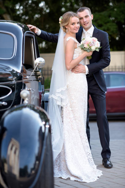 istock Wedding couple is hugging each other near a car 692055640