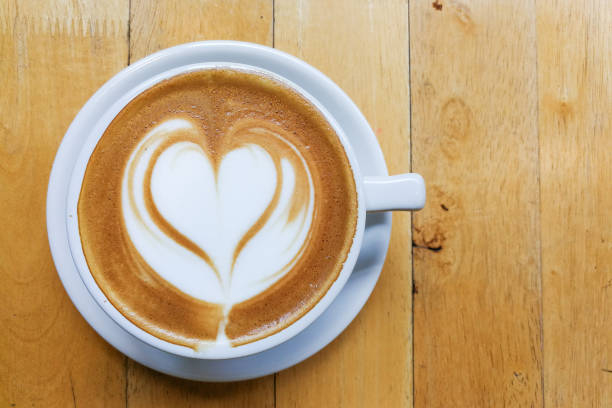 istock Cappuccino foam art with love heart shape on table 692056690