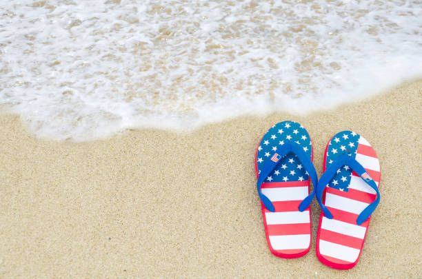 Patriotic USA background with flip flops on the sandy beach