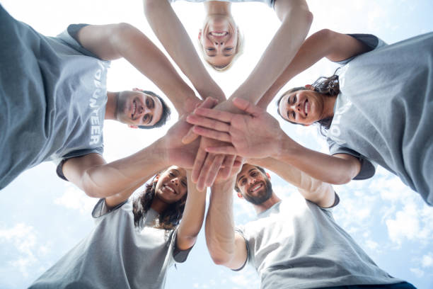 istock Happy volunteers putting their hands together 692064334