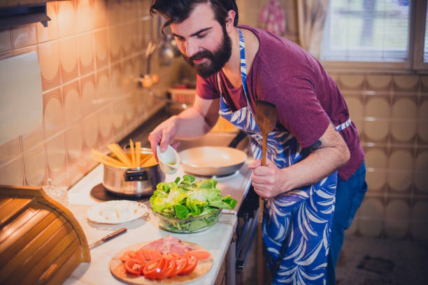 istock Handsome bearded man preparing sphagetti in the kitchen 692068338