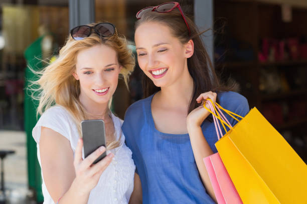 istock Happy smiling friends looking at smartphone 692074730