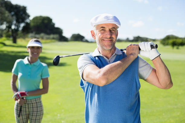 istock Happy golfer teeing off with partner behind him 692081092