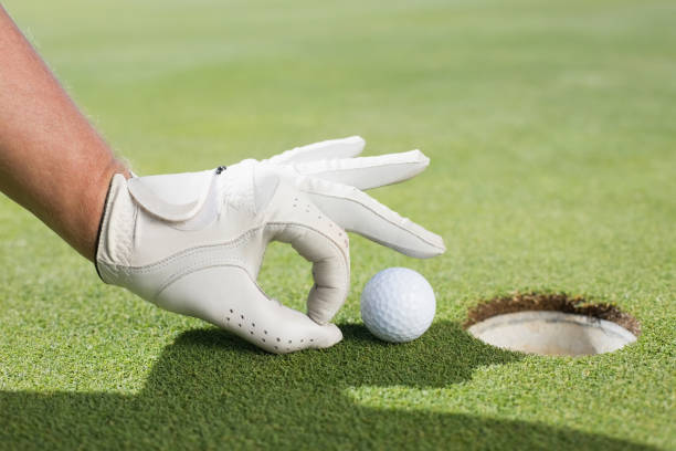 istock Golfer trying to flick ball into hole 692084220
