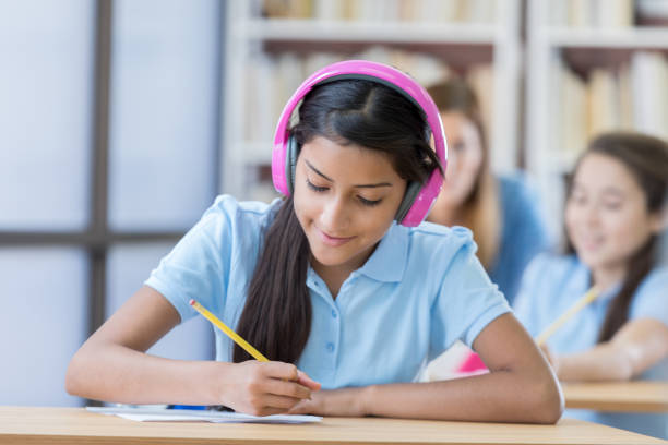 istock Hispanic girl wears wireless headphones in class 692087980