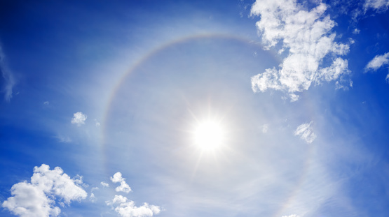 landscape from the blue sky with sun, white clouds and halo.  panorama  view halo