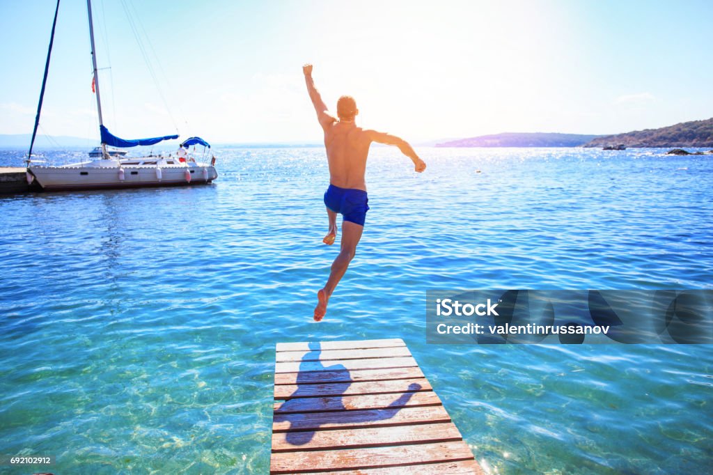Homem alegre, pulando na água - Foto de stock de Mergulhar na água royalty-free