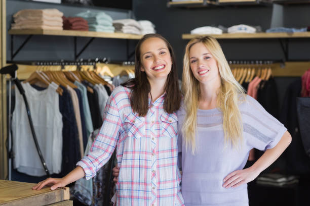 istock Two female friends standing together and smiling at camera 692105662