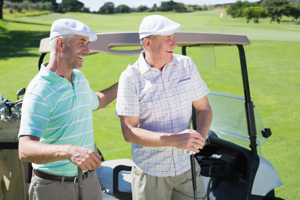 istock Golfing friends standing beside their buggy smiling 692106596