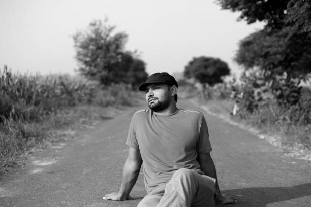 istock Young man sitting on country road 692109114
