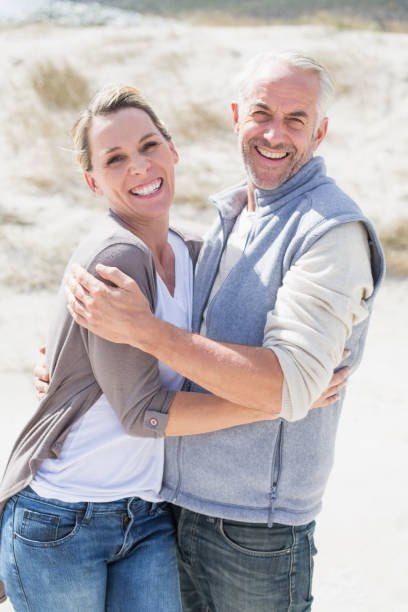 istock Happy couple hugging on the beach looking at camera 692109294
