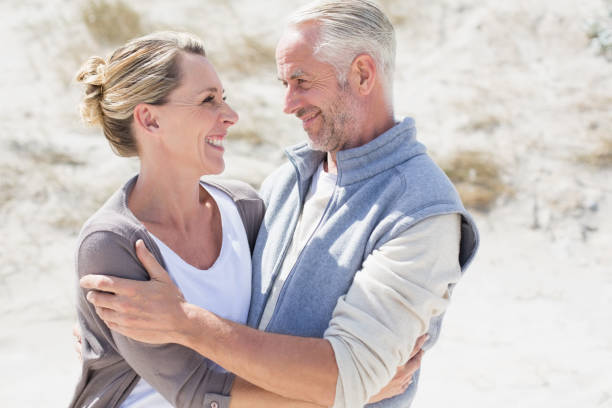 istock Happy couple hugging on the beach looking at each other 692109318