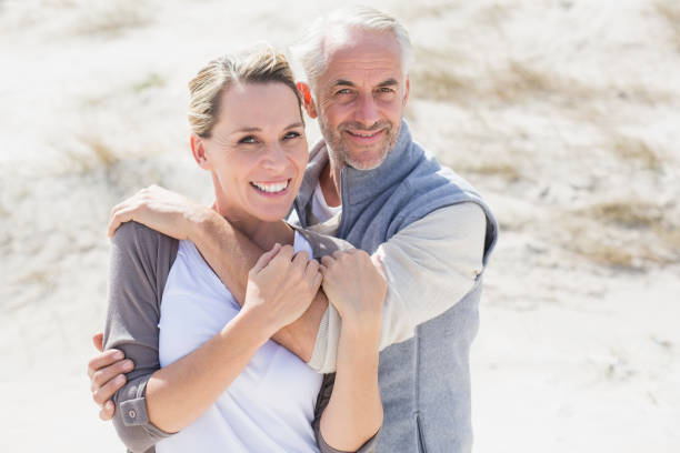 istock Happy hugging couple on the beach looking at camera 692109358