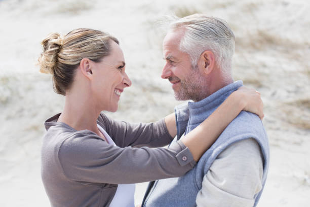 istock Happy hugging couple on the beach looking at each other 692109524