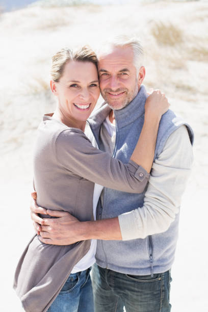 istock Happy hugging couple on the beach looking at camera 692109650