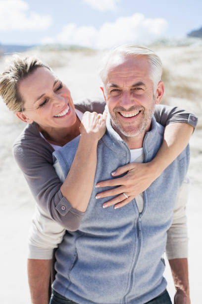 istock Happy hugging couple on the beach looking at camera 692109846