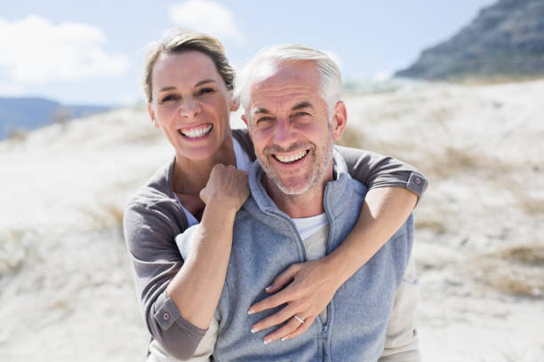 istock Happy hugging couple on the beach looking at camera 692109894