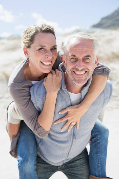istock Laughing couple smiling at camera on the beach 692112036