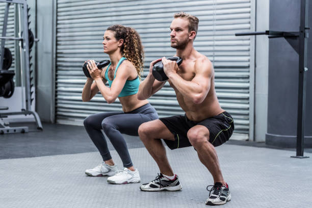 istock Muscular couple exercising with kettlebells 692122470