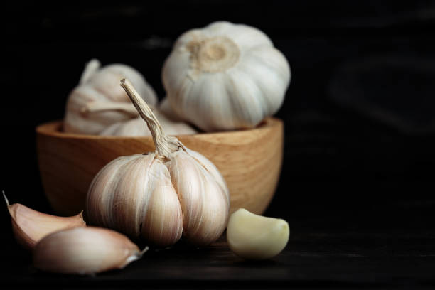 istock garlic ingredient herb on wood front view dark background 692123110