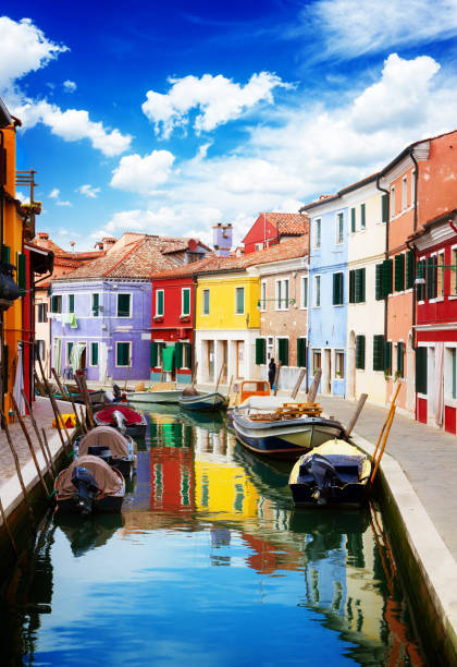 multicolored houses over canal with boats, street of Burano island, Venice Italy, vertical shot, retro toned