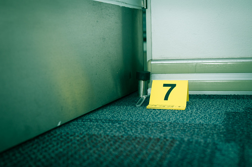 evidence marker number 7 on carpet floor with suspect object in crime scene investigation with copy space and cinematic tone