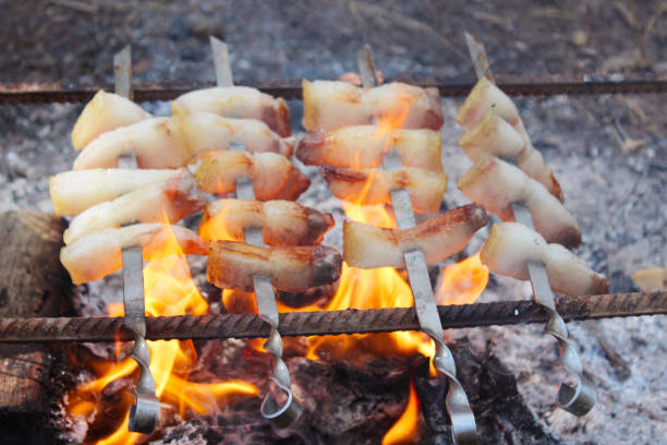 tasty fried pieces of lard cooking on the fire