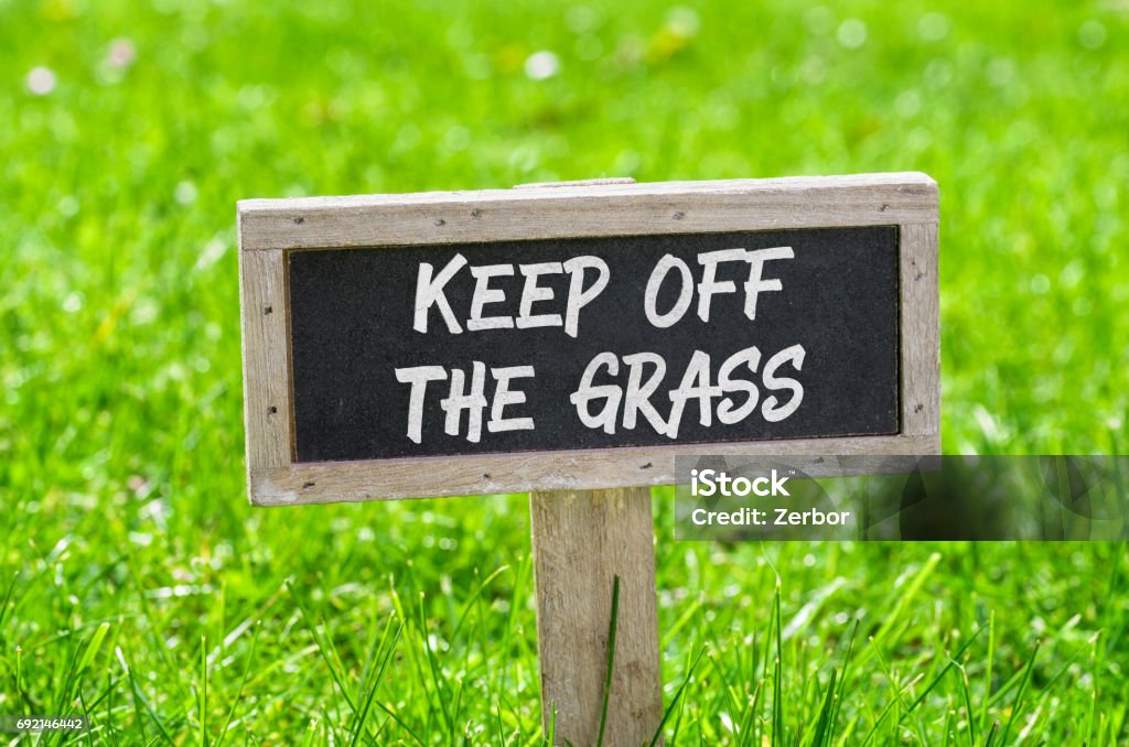 Sign on a green lawn - Keep off the grass Keep Off Lawn Sign Stock Photo