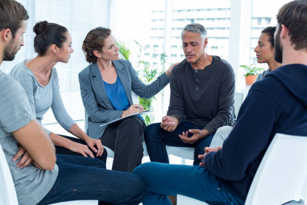istock Concerned woman comforting another in rehab group 692151280