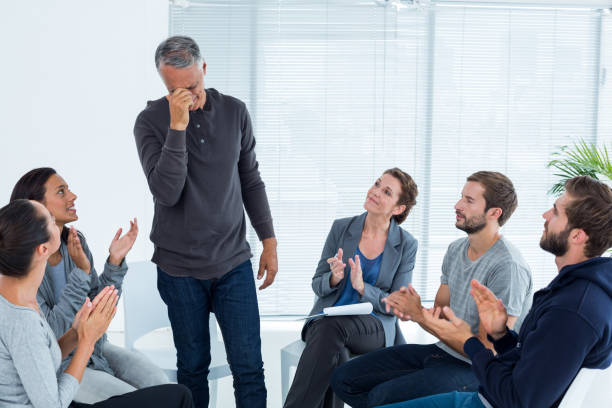 istock Rehab group applauding delighted man standing up 692154134
