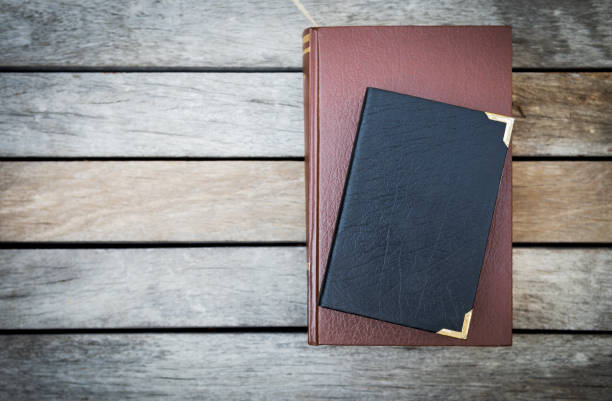 Old book with leather cover on vintage wooden floor Old book with leather cover on vintage wooden floor background, education concept, outdoor day light old black leather photo album stock pictures, royalty-free photos & images