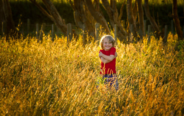cute blonde child in a field at sunset