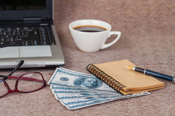 istock Selective focus office table : eyeglass , laptop, note book and cup on the wooden 692162034
