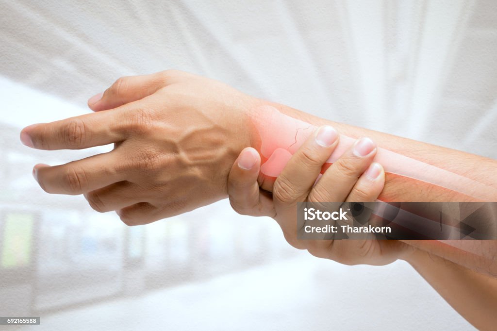 L’homme massage poignet douloureux sur un fond blanc. Notion de douleur - Photo de Fracture libre de droits