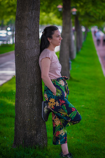 woman leaning on the tree