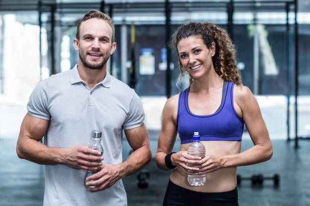 istock Smiling muscular woman with her trainer 692169604