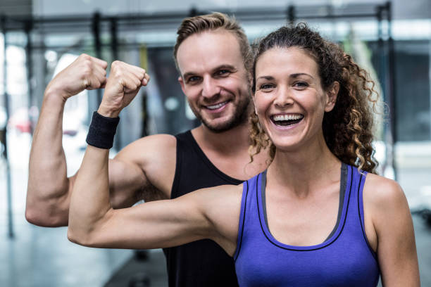 istock Smiling muscular couple flexing biceps 692171718