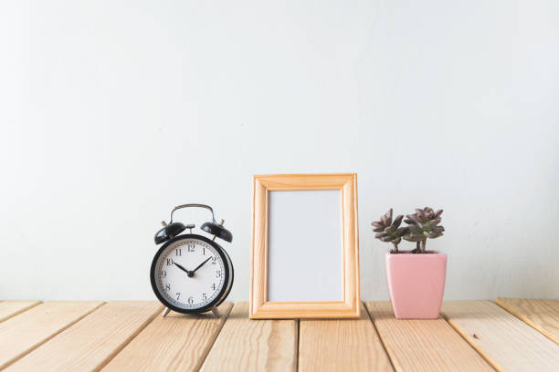 istock Plants and alarm clock on a white wall shelf 692171744