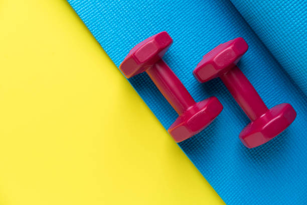 istock dumbbell and yoga mat on yellow background 692171824