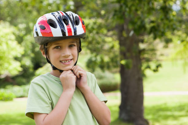 istock Smiling boy wearing bicycle helmet at park 692172062