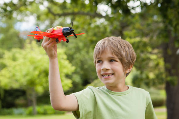 istock Boy playing with a toy plane at park 692172108