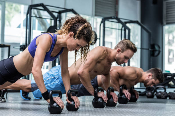 istock Three muscular athletes on a plank position 692172358