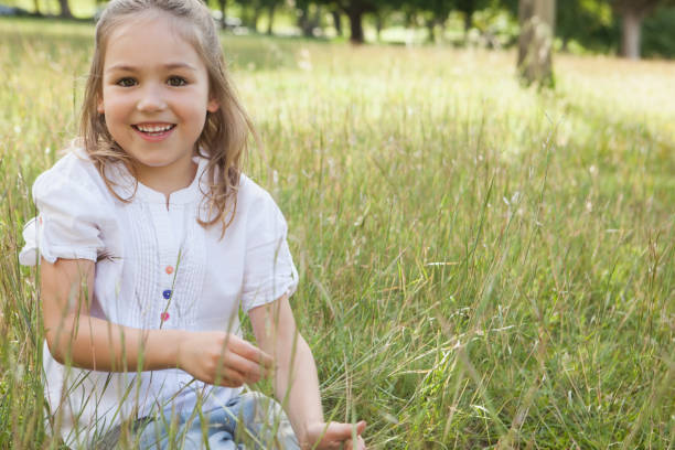 istock Smiling relaxed young girl sitting in field 692179066